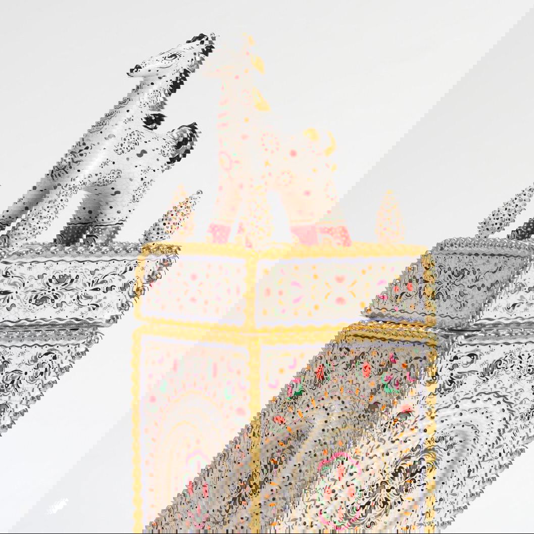 Высокая прямоугольная шкатулка с фигурой стоящего коня на верхней части, декорирована мелкой цветной росписью и золотой каймой.