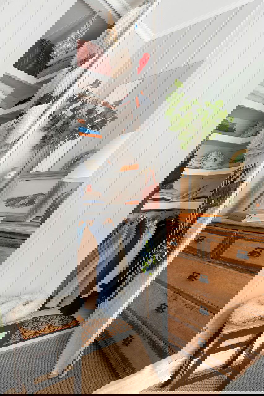 Угловой шкаф с множеством полок для свитеров, сумок и аксессуаров рядом с комодом — решение для компактного хранения вещей в прихожей или спальне.