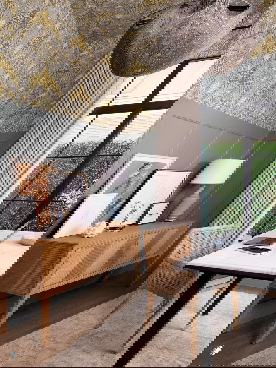 Комната с панелями на стенах и декоративным обоями у верхней части, светлый потолок и крупные окна создают контраст и визуальную глубину интерьера.