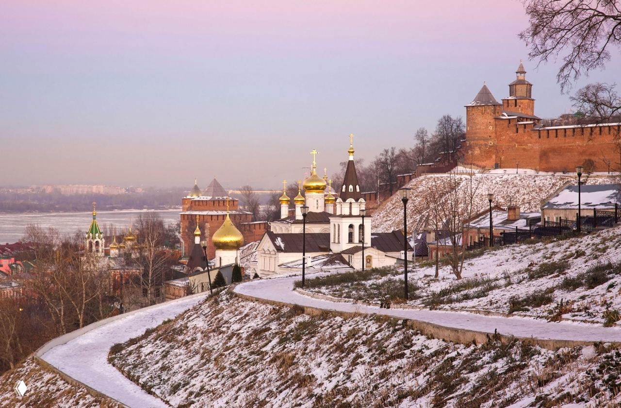 Подснежный склон у Нижегородского кремля: тропинка, золотые купола церквей и старинные укрепления на фоне реки.