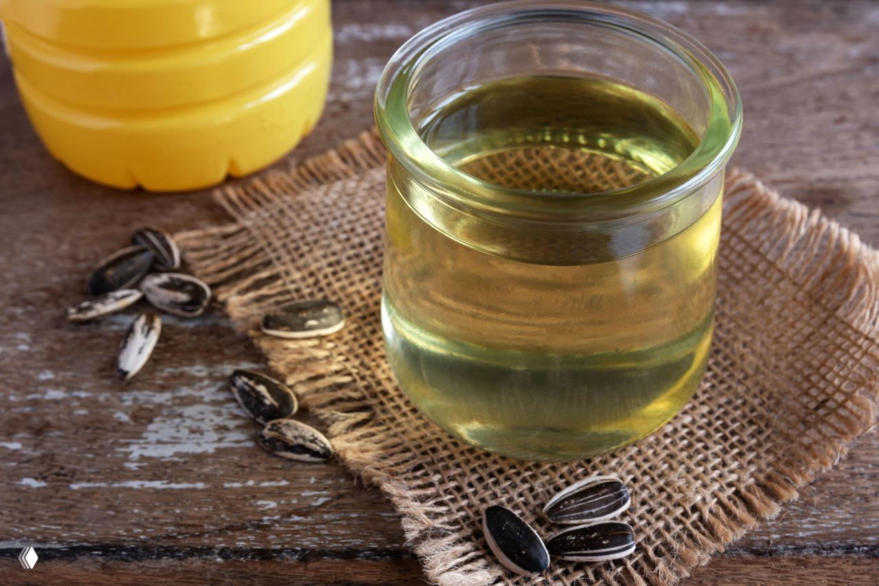 Банка с растительным маслом и семечками на деревянной поверхности — иллюстрация применения масла для удаления клея.