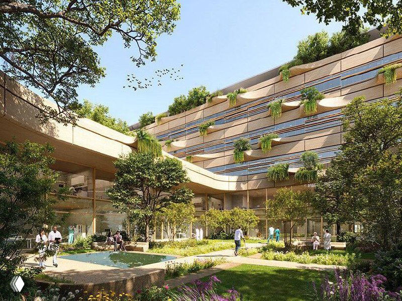 Фрагмент фасада и террасной структуры проекта больницы Мальпенса: ступенчатые плоскости, озеленённые уступы и мягкие архитектурные линии на фоне деревьев.