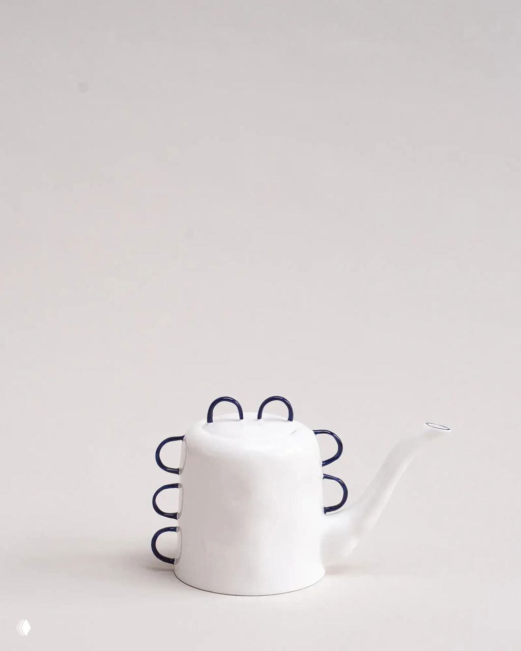 Чайник Feldspar, поставленный вверх дном, с рядом дополнительных синих ручек по боковой поверхности на нейтральном фоне.