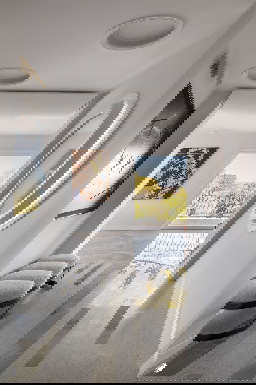 Холл квартиры с комбинированным покрытием пола: вставки паркета и полированного оникса, вид на окно с балконом и зелёной долиной за ним.