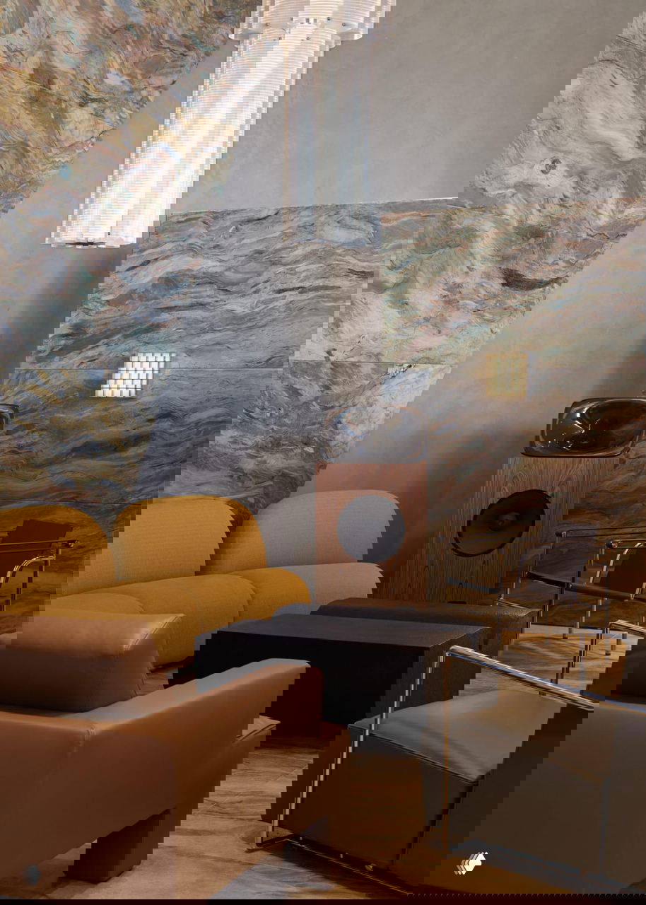 Лаунж-зона кафе Daily Press: мягкие кресла и диваны, акустическая колонка и стена, отделанная разноцветной плиткой зеллидж с декоративной подсветкой.