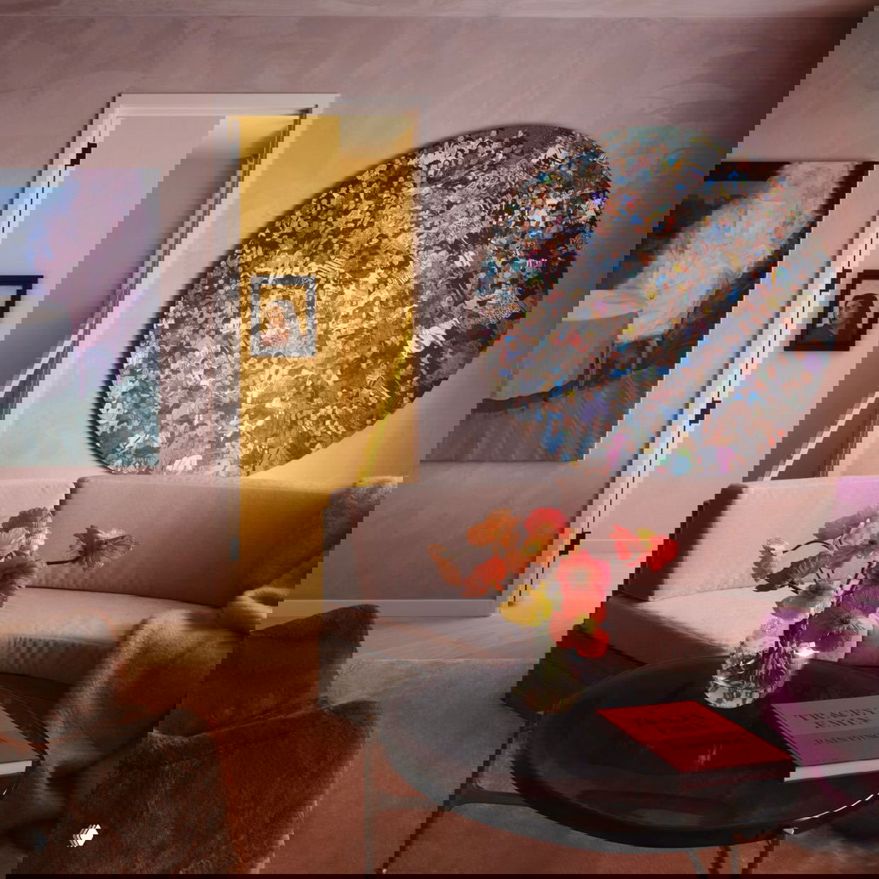 Уютная зона отдыха с мягким диваном, круглым столиком и большой круглой картиной на розовой стене; в дверном проёме видна ярко-жёлтая стена детской.