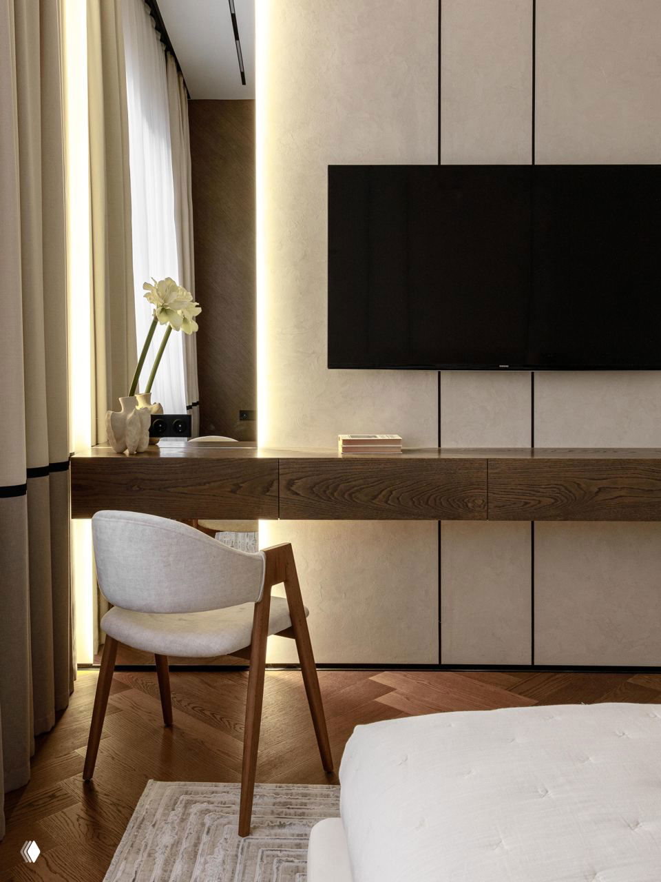 Рабочая зона у окна: плавающая деревянная консоль под телевизором, удобное кресло и акценты мягкого света на фоне нейтральных стен.