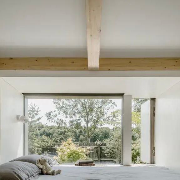 Большое панорамное окно в гостиной плавучего дома: просторный светлый интерьер и вид на природу у берега канала, соединяющий дом с окружением