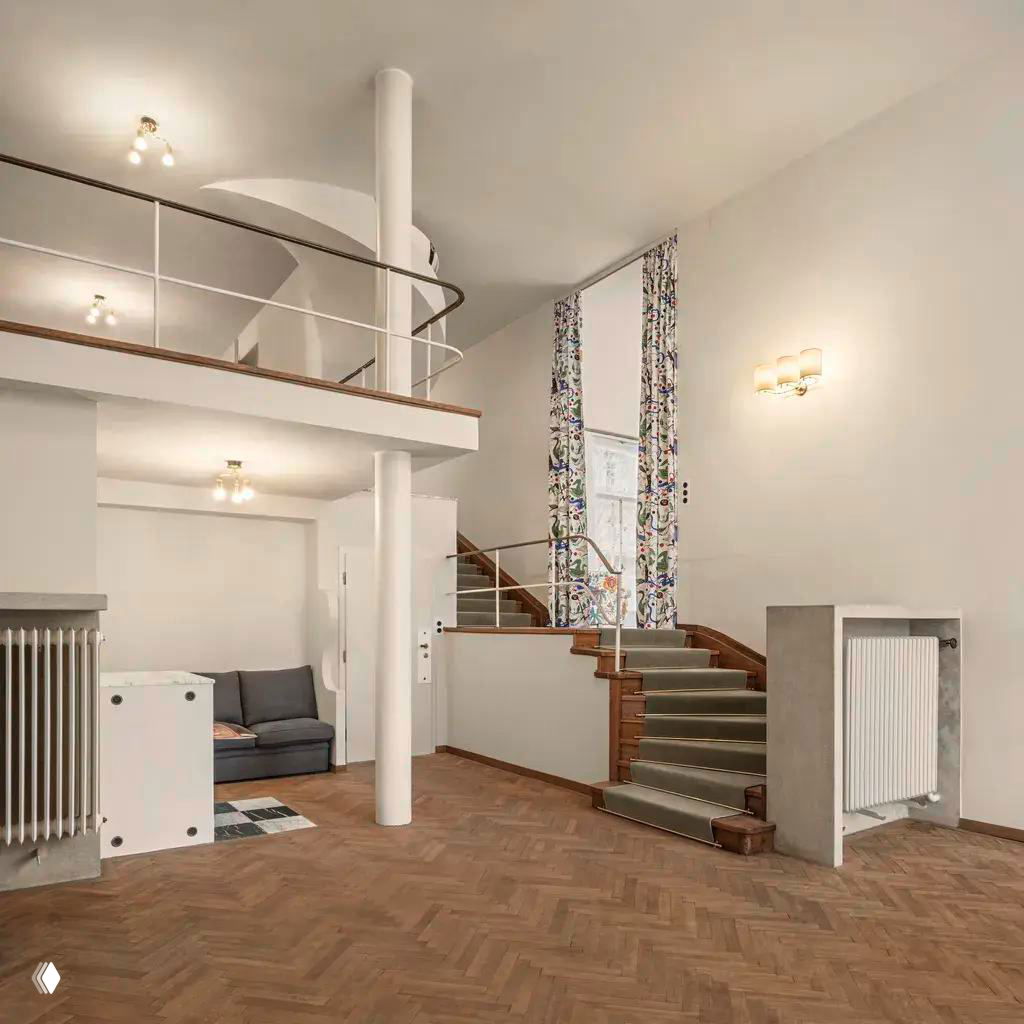 Интерьер виллы Beer: лестница с деревянными ступенями, металлические перила, паркетный пол и светлые стены в атмосфере отреставрированного модернизма.