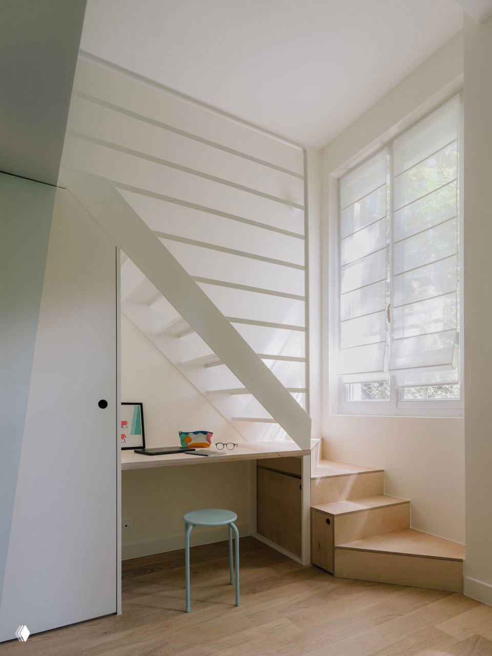 Вид на вход в санузел и встроенные стеллажи из фанеры под мезонином; узкие дверцы и арочные ниши создают компактное, корабельное чувство пространства.