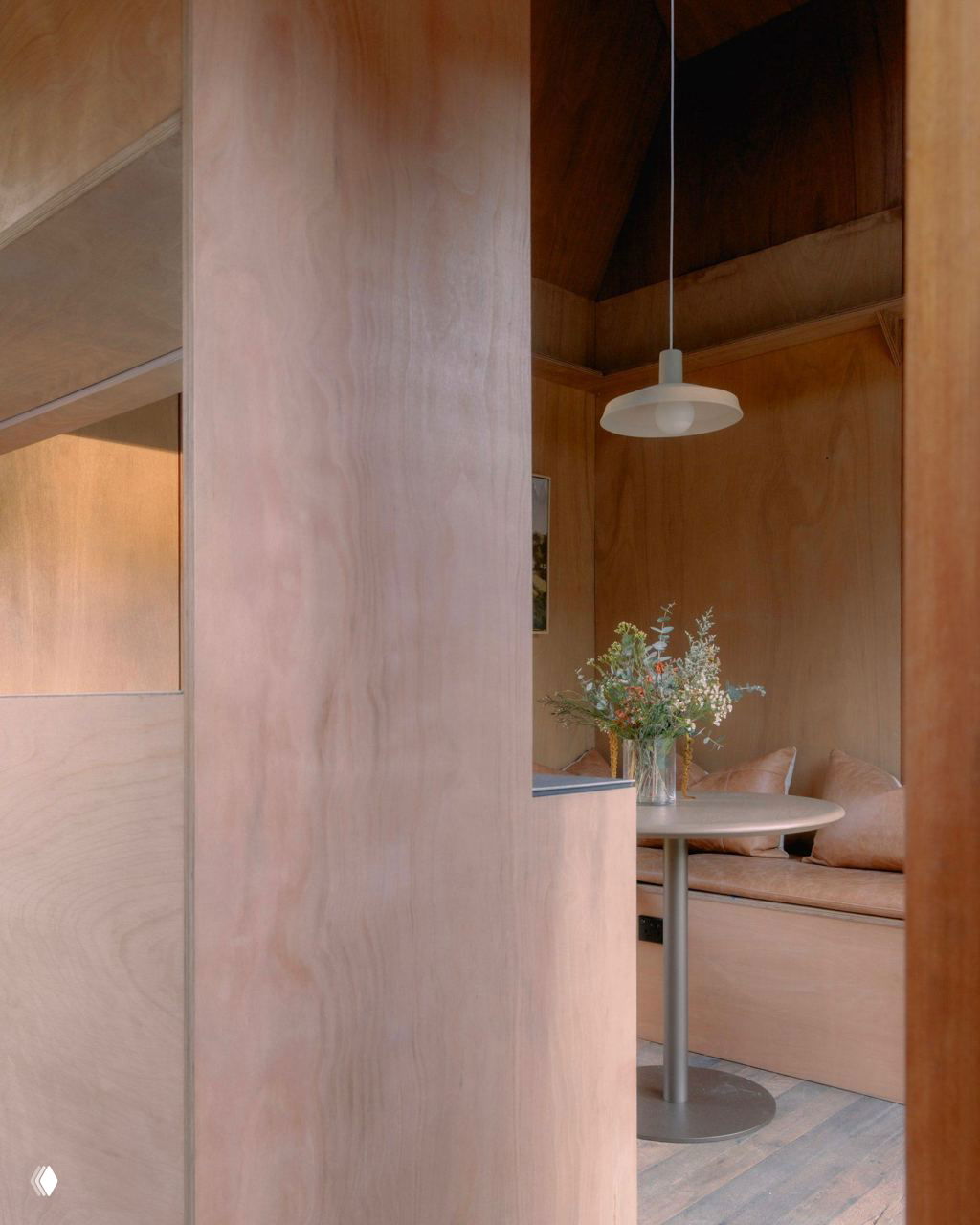 Обеденная ниша с встроенным диваном и круглым столом: мультфункциональная мебель, скрытые отделения и приглушённое освещение.