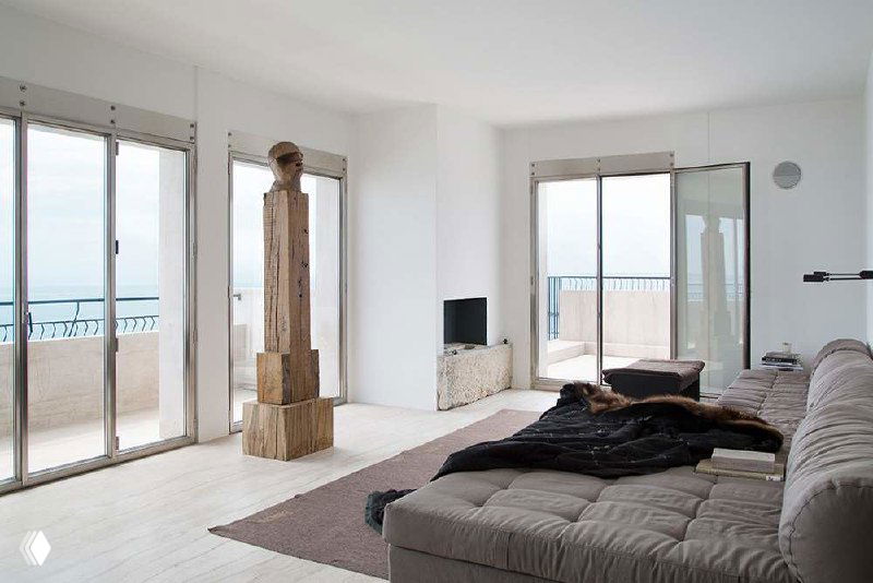 Спальня-лофт с низкой кроватью и крупными наклонными окнами, светлая палитра и минималистичная текстура материалов.