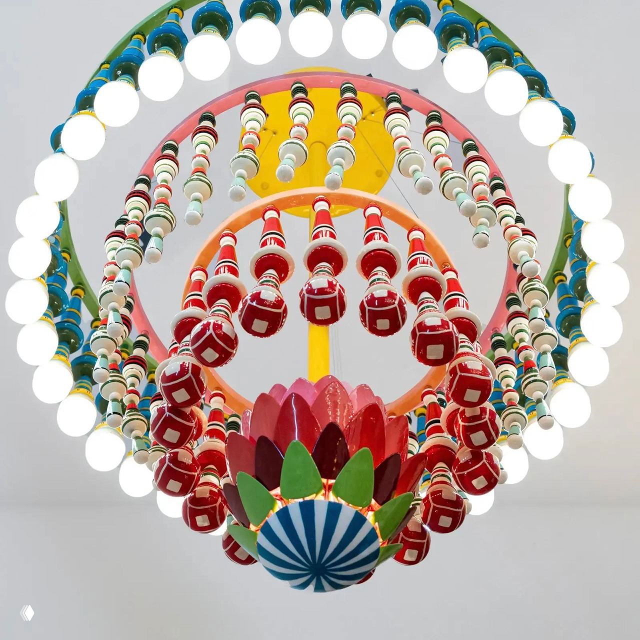 Крупная декоративная люстра из разноцветных колец и подвесных элементов, составная арт-лампа с множеством лампочек и керамических шаров.