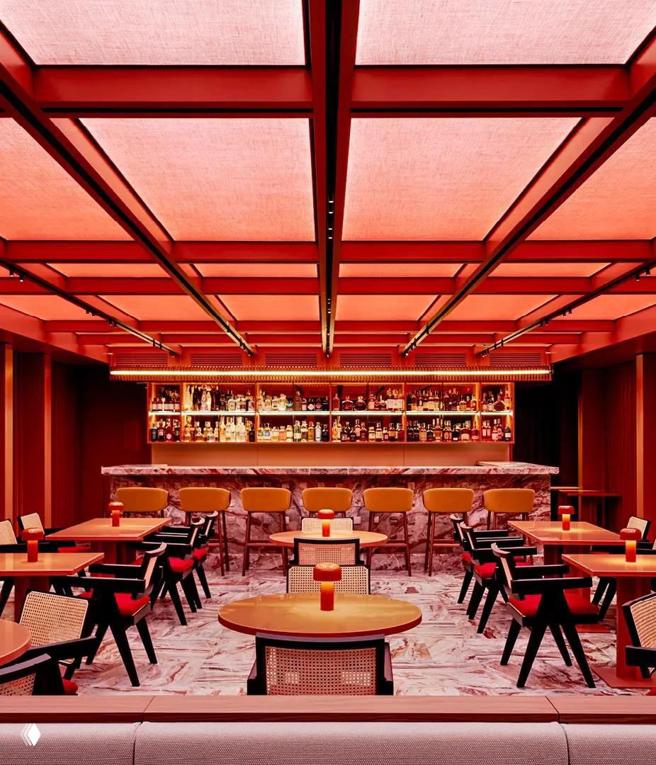 Ресторан или бар Casa Brera: тёплая красная подсветка потолка, барная стойка из камня и ряд столов с креслами в лаконичном стиле.
