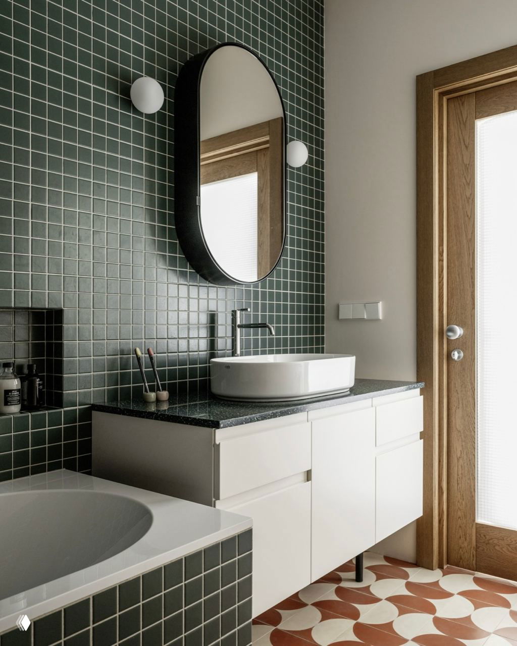 Ванная комната с тёмно‑зелёной настенной плиткой и белой раковиной; пол украшен круговыми орнаментами тёплого кирпичного цвета.