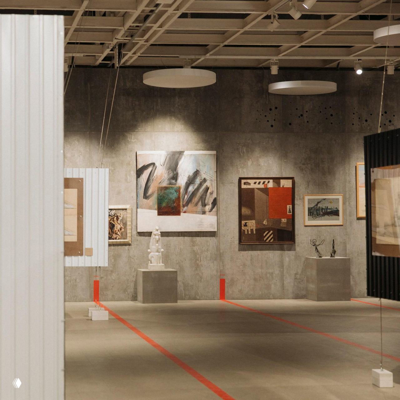 Интерьер выставочного зала с живописью и скульптурами на подиумах: выдержанная экспозиция фестиваля внутри пространства Манежа.