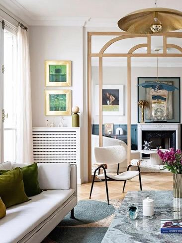 Гостиная с радиатором и декоративными полками по периметру; полки над батареей используются для книг и предметов декора, оптимизируя пространство