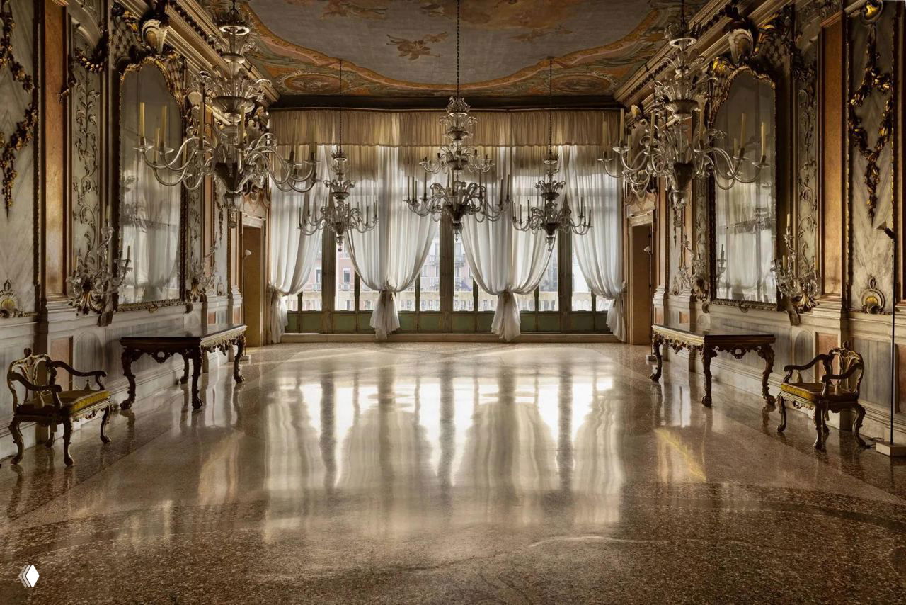 Бальный зал палаццо с высокими окнами, зеркалами и хрустальными люстрами: просторное помещение Studio San Polo для выставок и творческих экспериментов.