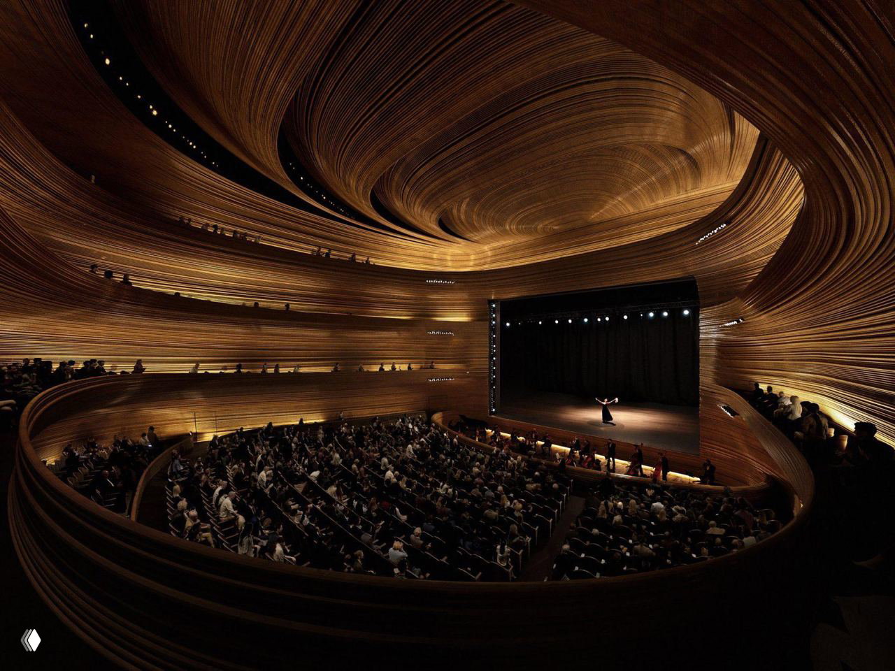 Интерьер главного зала оперы: деревянные волнообразные оболочки, амфитеатр с публикой и сцена, тёплые натуральные материалы в отделке.