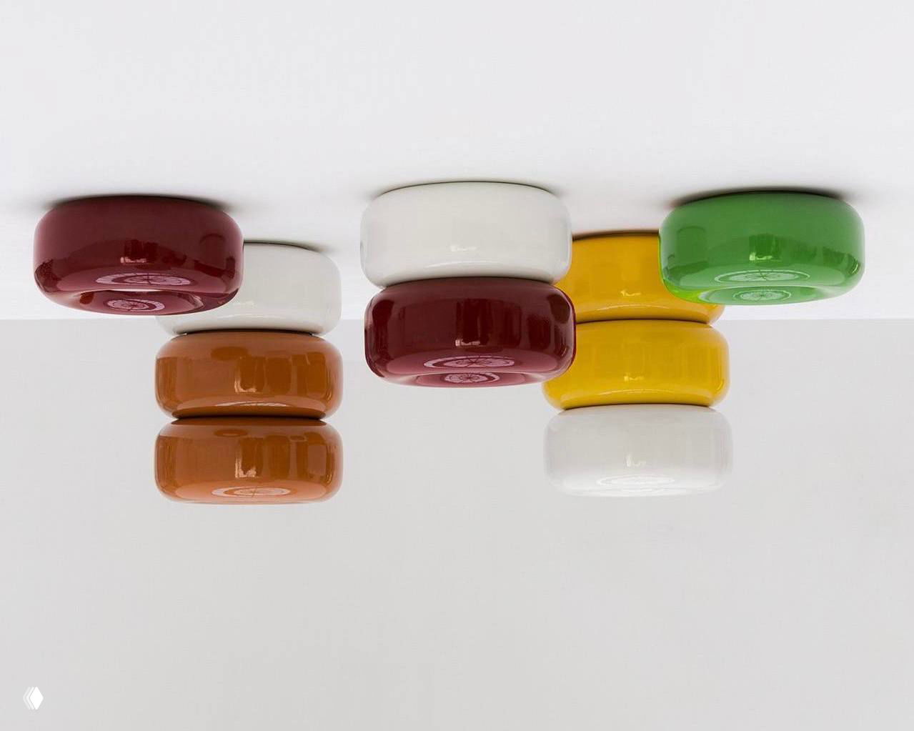 Крупный план потолочных керамических модулей коллекции Caramel: глянцевая глазурь и округлые формы, вид снизу на несколько штук, разного цвета.