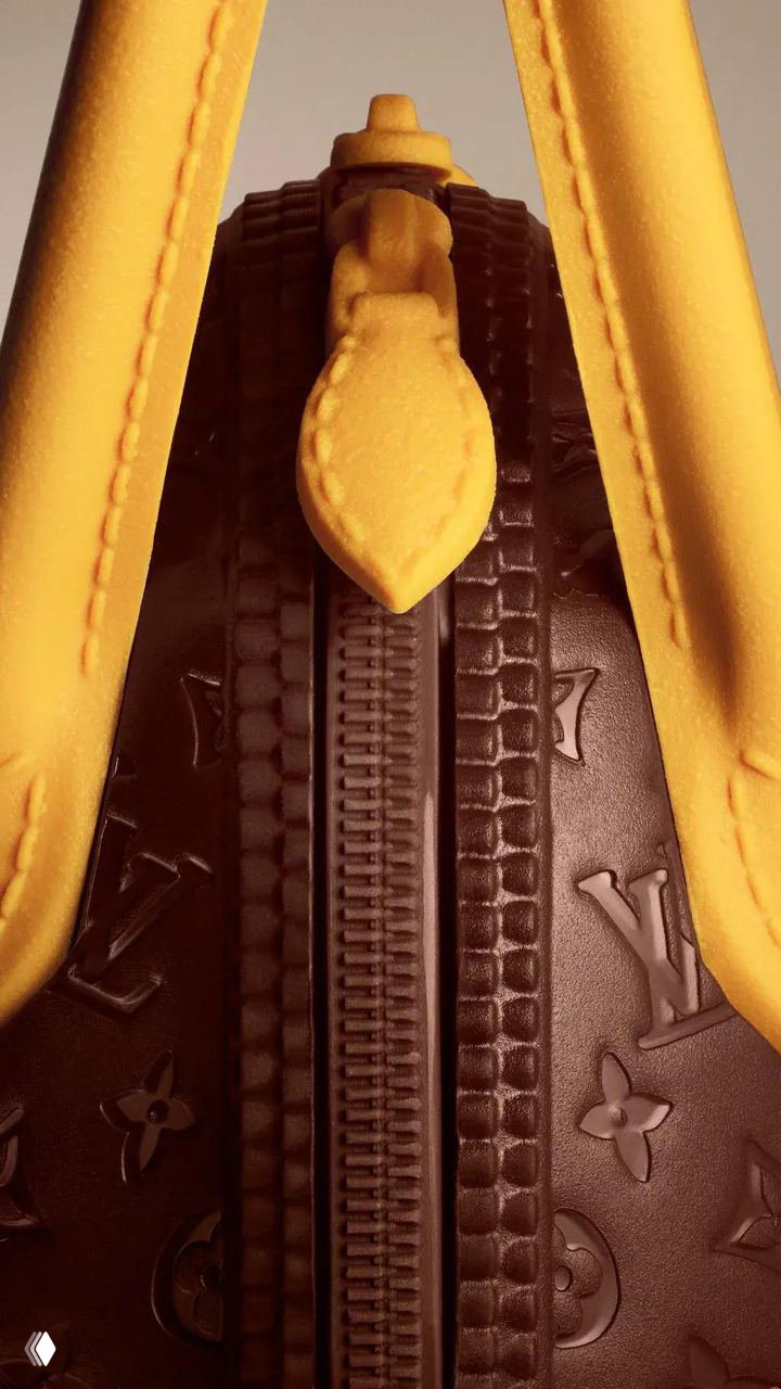 Крупный план застёжки и ручки шоколадной сумки-яйца Louis Vuitton: детали молнии, фактура монограммы и жёлтый декор.