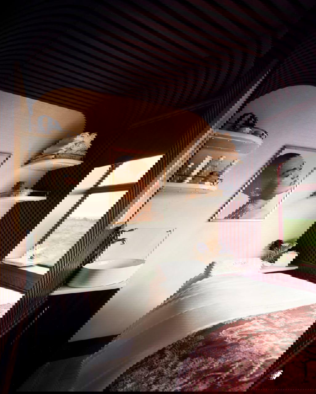 Спа-пространство Dior в купе поезда: массажная кушетка, аккуратно сложенные полотенца и косметические средства на полках рядом с окном