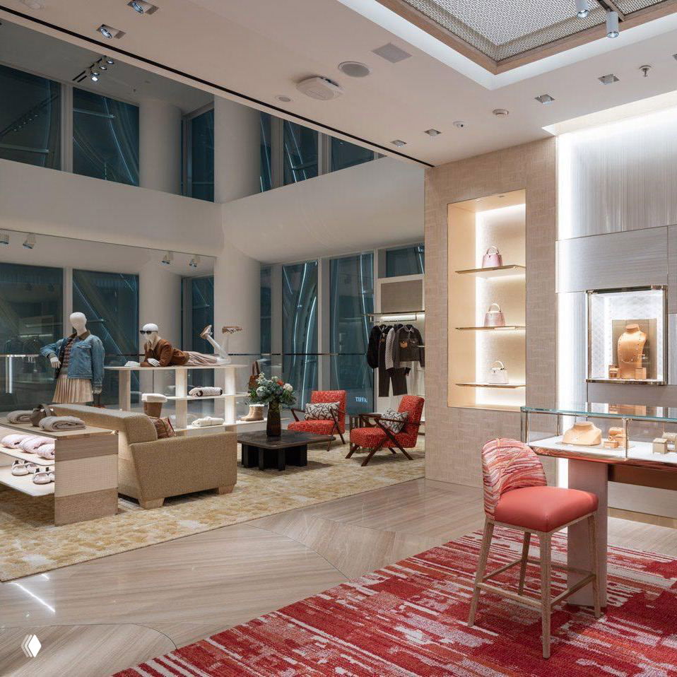 Зона продаж и демонстрации коллекций в бутике Louis Vuitton: отделка в светлых тонах, мебель и экспозиционные стенды с сумками и аксессуарами.