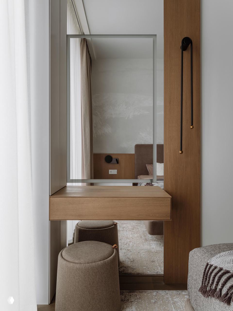 Зона у окна с зеркалом и деревянной панелью: небольшое туалетное место с пуфами и функциональным минимализмом, вписывающимся в концепцию проекта.
