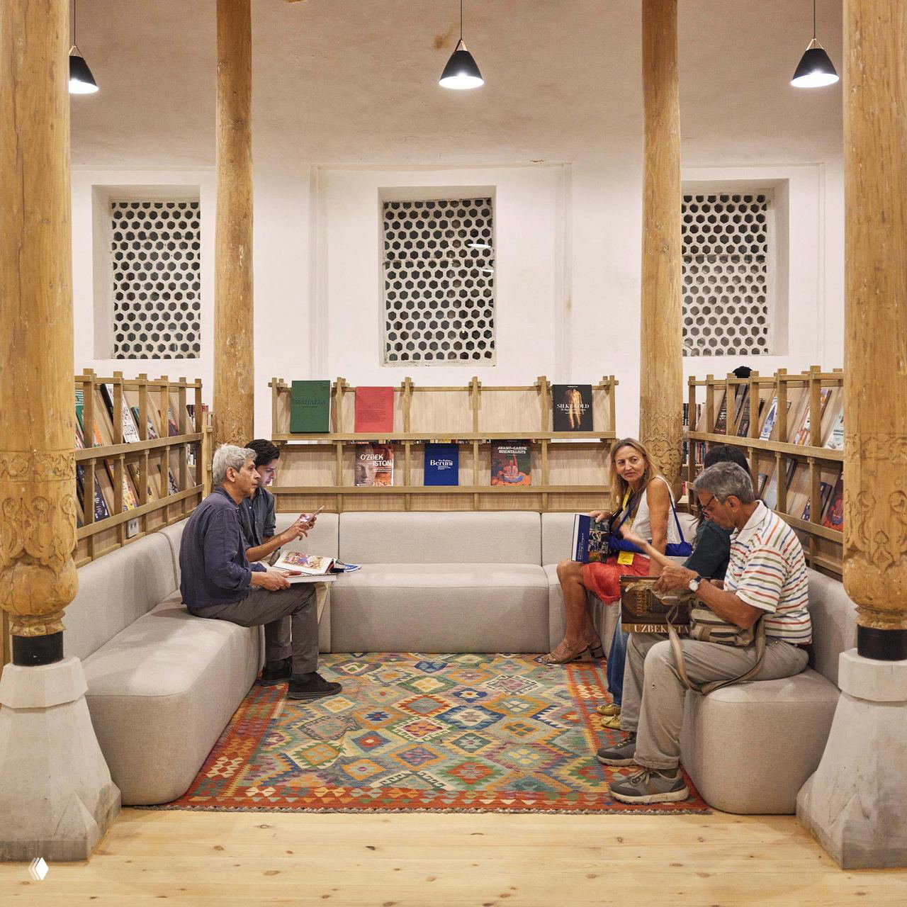 Уютная зона чтения и общения с диванами, деревянными колоннами и полками с журналами — образовательная и библиотечная часть фестиваля для посетителей.