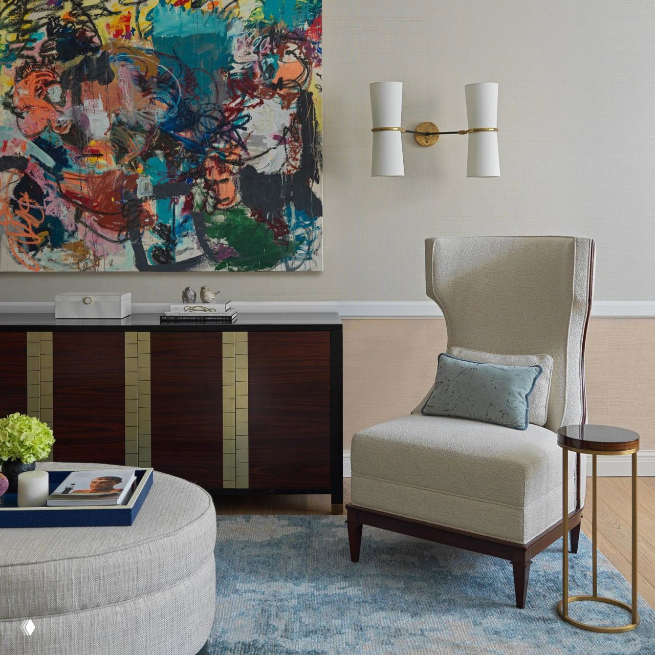 Уютный уголок с высоким креслом и парой симметричных настенных бра над буфетом; пример декоративного светильника для чтения и акцентов в гостиной.