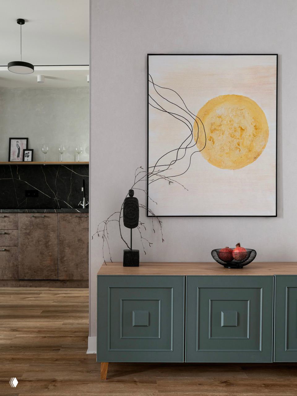 Прихожая и комод с зелёной патиной, над ним большая картина с тёплым солнечным мотивом; декоративная керамика и аксессуары на столешнице.