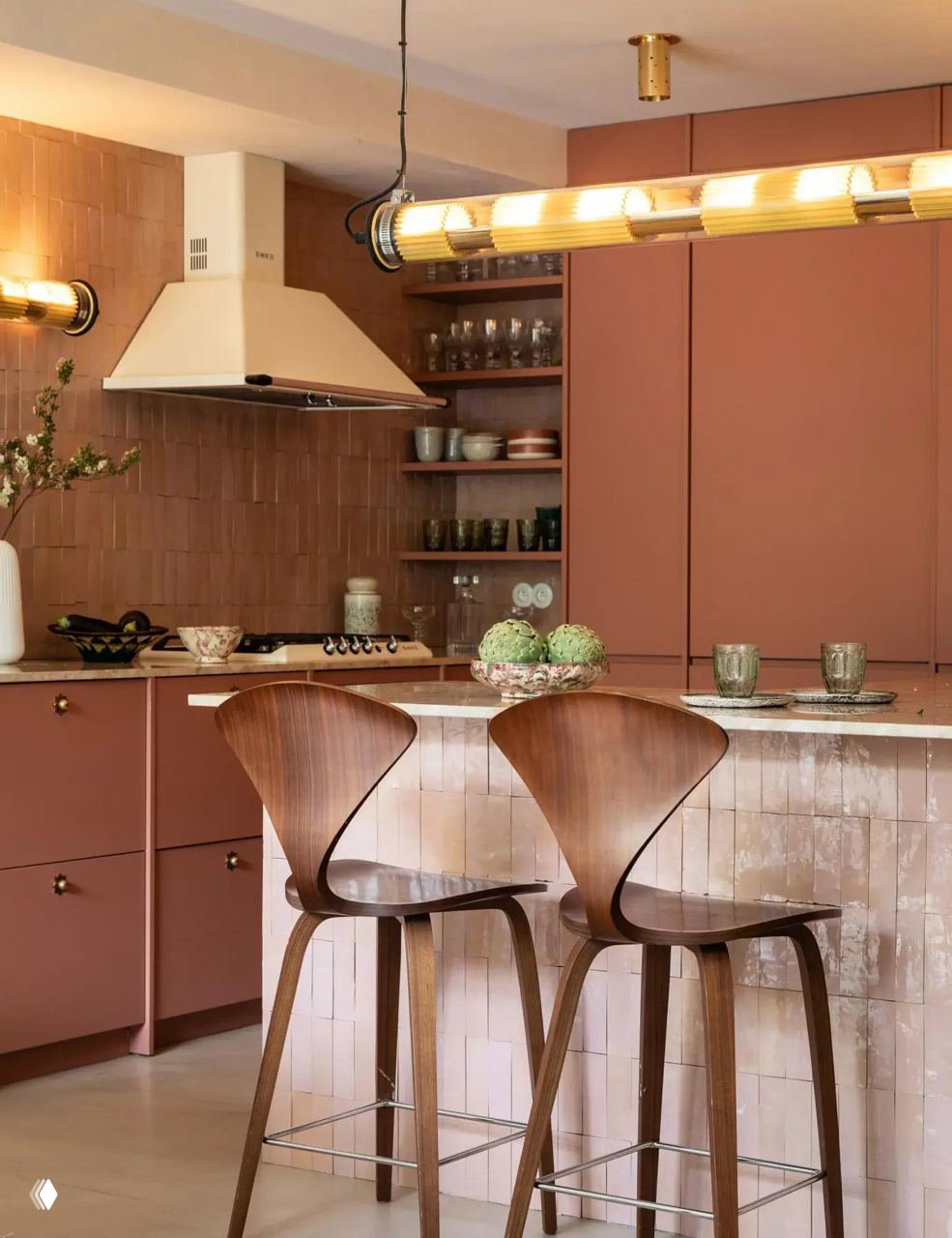 Кухня в терракотовых и пудровых оттенках с барной стойкой, деревянными стульями и декоративной подсветкой — тёплый уютный интерьер.