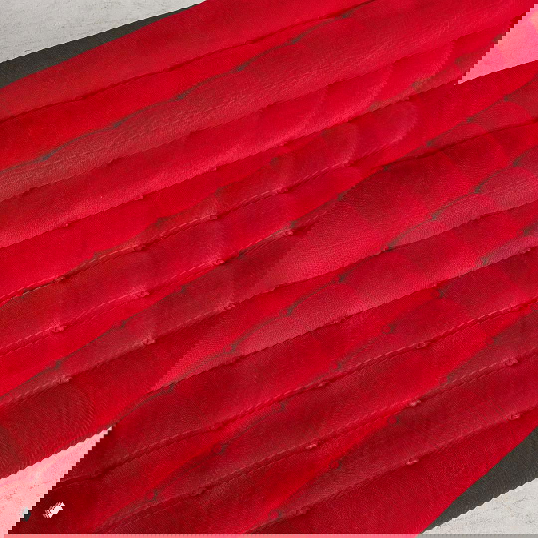 Крупный план красной стёжки дивана IKEA Impala с тканевой фактурой, видны аккуратные пуговицы и ритмичная сетка стёжки на обивке — деталь винтажного изделия.