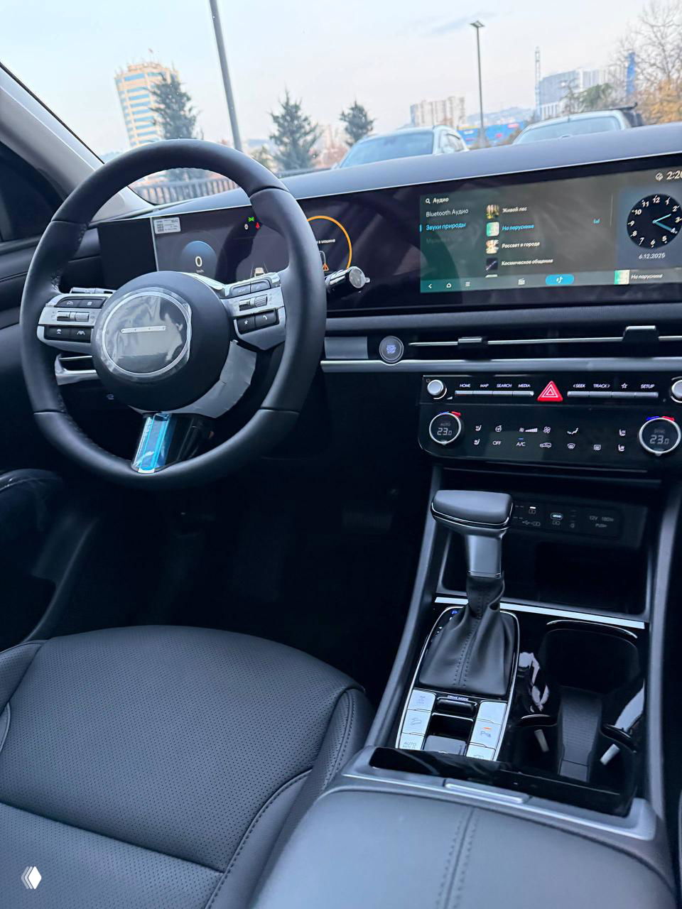Передняя панель и руль Hyundai Tucson 2025: 12,3" сенсорный дисплей, цифровая приборная панель, селектор коробки передач и элементы управления на руле.