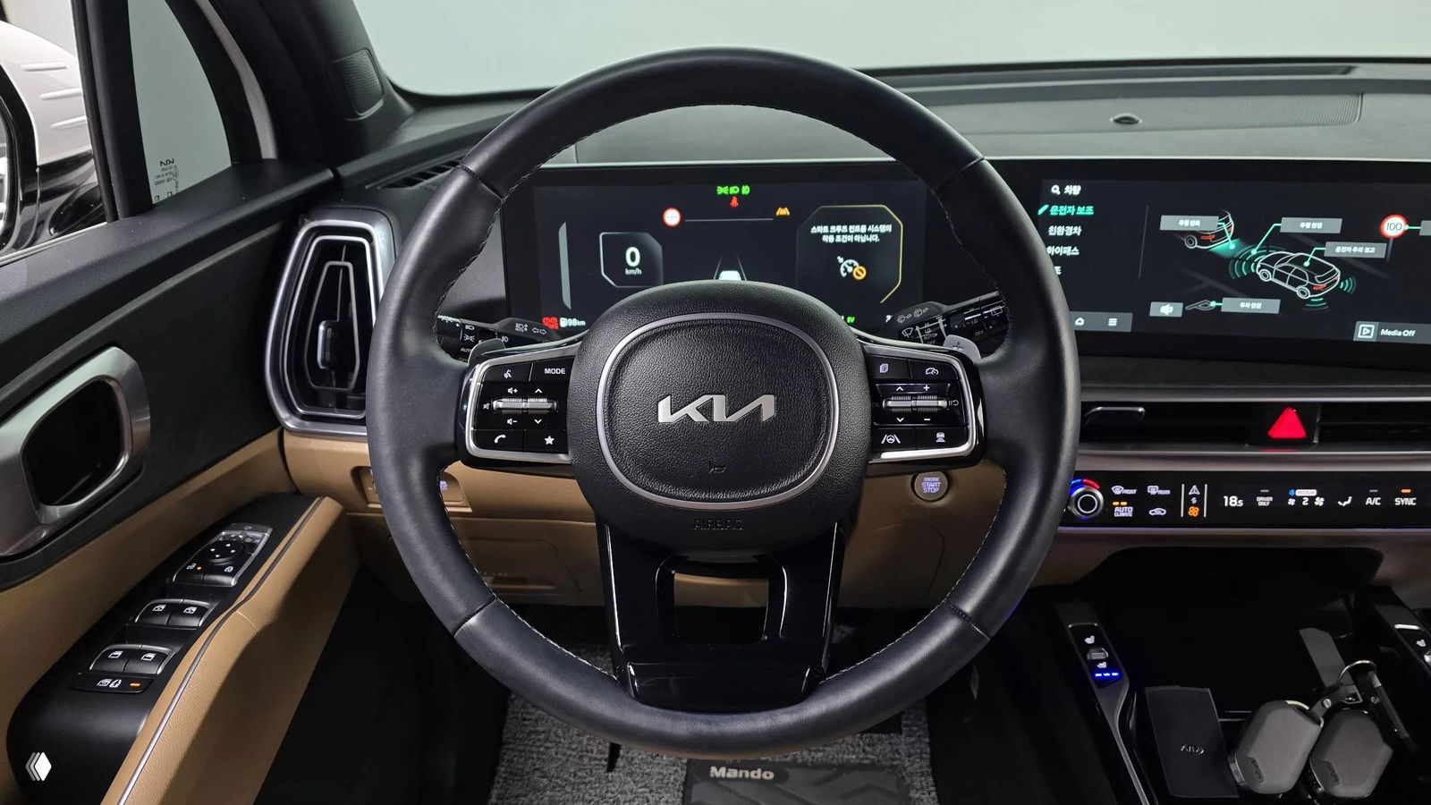 Рулевое колесо KIA с новым логотипом, панель цифровых приборов и широкий дисплей мультимедиа, крупный план салона.