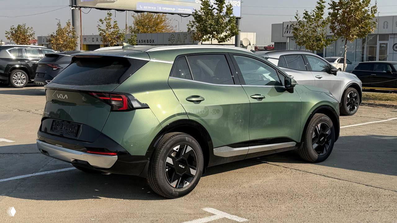 Зелёный KIA Sportage 2025, вид сзади и под углом на стоянке, демонстрация задней оптики, линии кузова и облицовки бампера.
