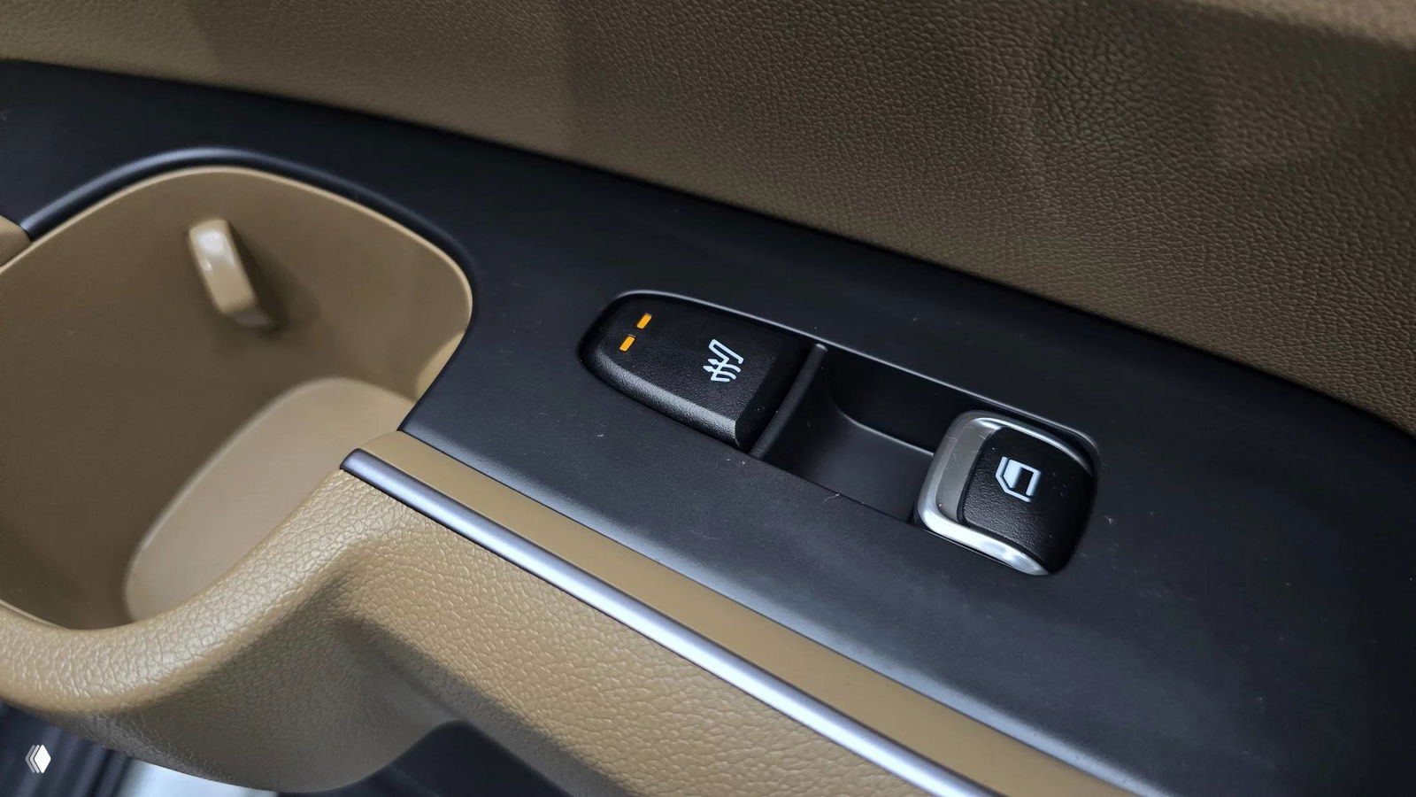 Крупный план блока кнопок и подстаканника в дверной панели KIA Sorento, детали отделки и элементы управления закрытием/подогревом.