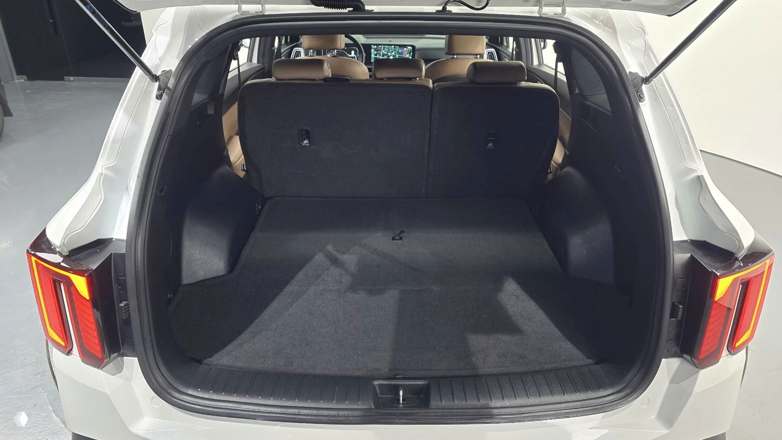 Багажник KIA Sorento 2024 с открытой крышкой, просторный грузовой отсек и вид на задние сиденья в сложенном положении частично.