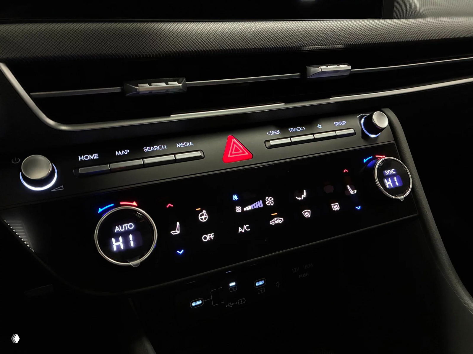 Крупный план панели управления и климат-контроля Hyundai Sonata: регуляторы с цифровыми индикаторами, кнопки HOME, MAP, MEDIA и подсветка приборной панели в тёмном салоне.