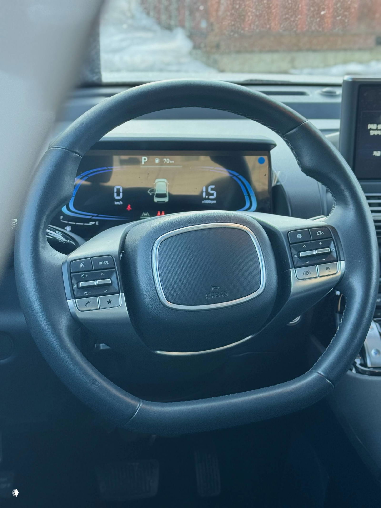 Крупный план рулевого колеса и цифровой приборной панели Hyundai Casper: центральный дисплей, элементы управления на руле и чистая передняя панель.