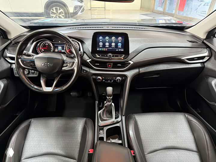 Общий вид передней части салона Chevrolet Orlando: два передних кресла, центральная панель, селектор передач и пространство для ног визуально в хорошем состоянии.