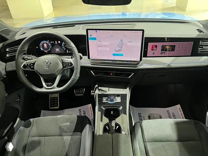 Салон Volkswagen Tiguan L Pro: руль, цифровая приборная панель и большой центральный экран мультимедиа, вид спереди.