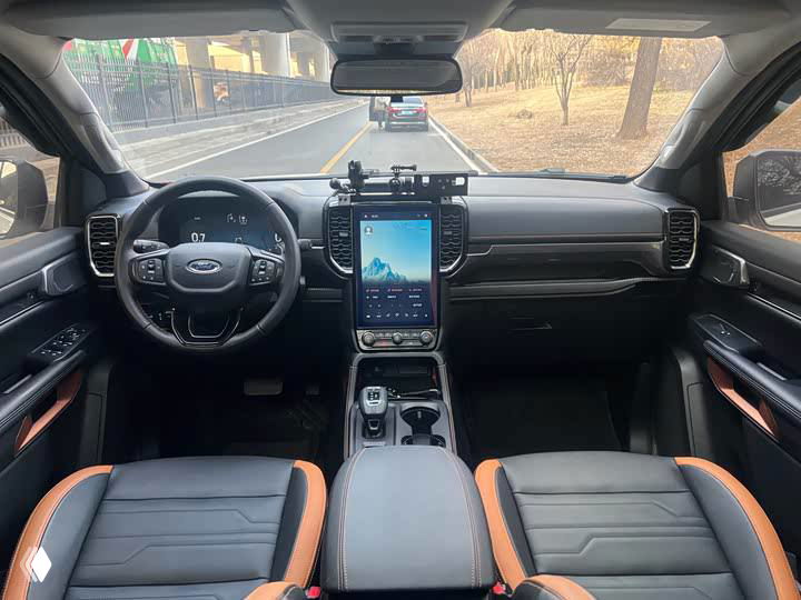 Интерьер Ford Ranger: вид на руль, центральную консоль с большим вертикальным сенсорным дисплеем и современную приборную панель, элементы управления на уровне водителя.