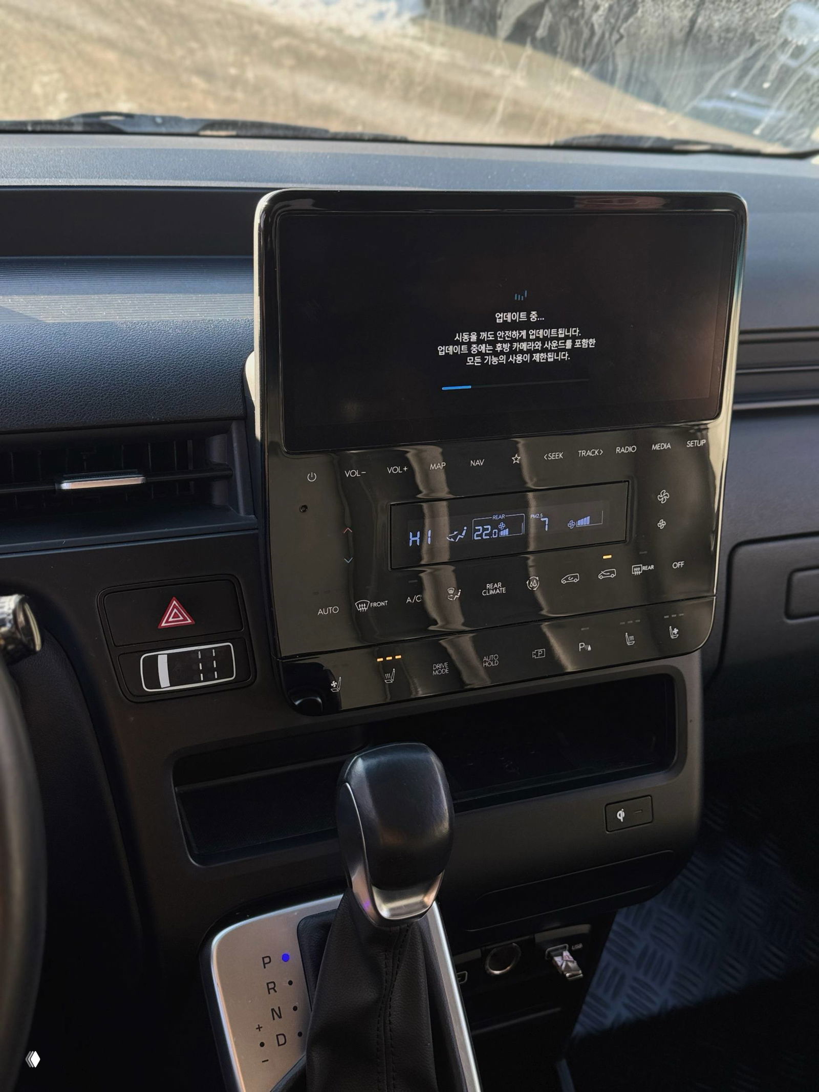 Центральная консоль и большой сенсорный экран мультимедиа Hyundai Staria с текстом обновления на экране, селектор АКП и элементы управления климатом.