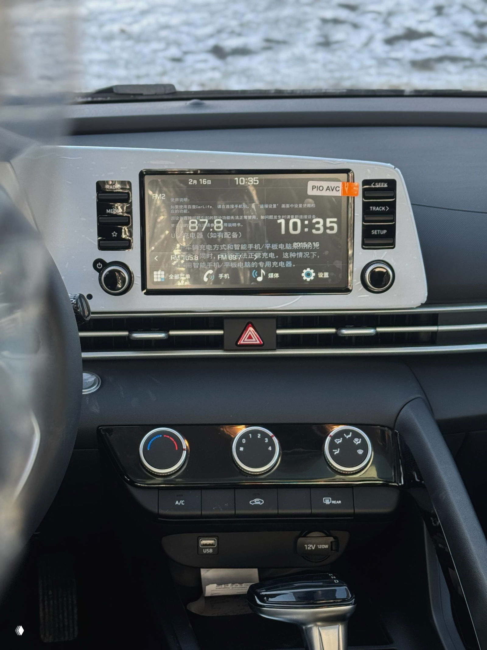 Мультимедийный экран центральной панели Hyundai Elantra с китайскими надписями, часы на экране и элементы управления магнитолой.