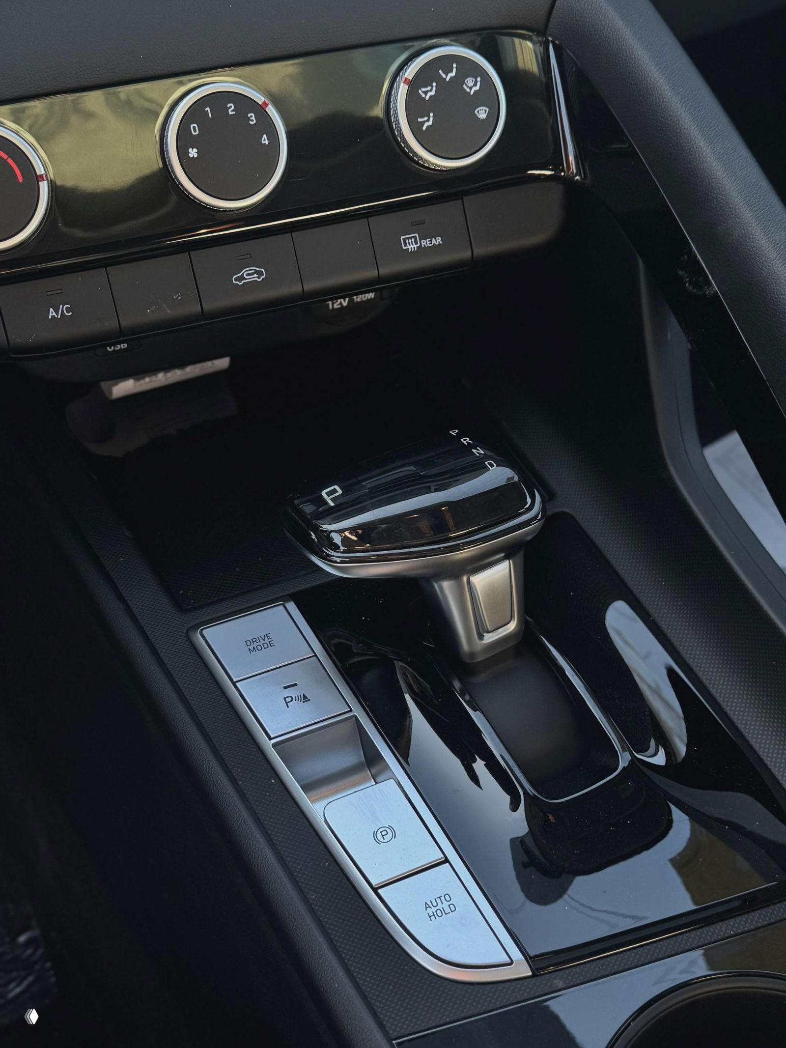 Ближний план селектора передач и кнопок Drive Mode, P, Parking и Auto Hold на центральной консоли Hyundai Elantra, хромированные акценты.