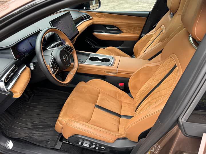 Вид пассажирских и водительских сидений Mazda EZ-6 — коричневая комбинированная обивка с поддержкой и регулировкой, эргономика салона на переднем плане.