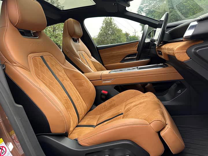 Фотография передних сидений и панорамной крыши Mazda EZ-6: вид под углом, показаны контуры подголовников и снабжение освещением в салоне.