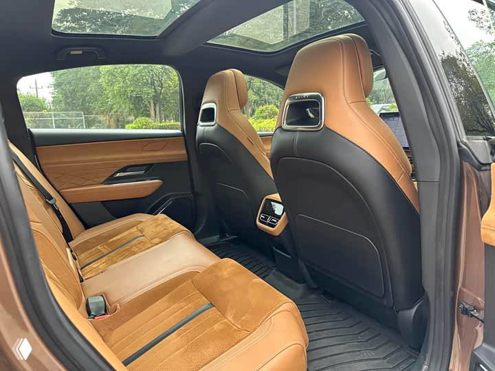 Задние сиденья Mazda EZ-6 с коричневой отделкой, пространство для пассажиров, вентиляционные дефлекторы и общий вид второго ряда салона.