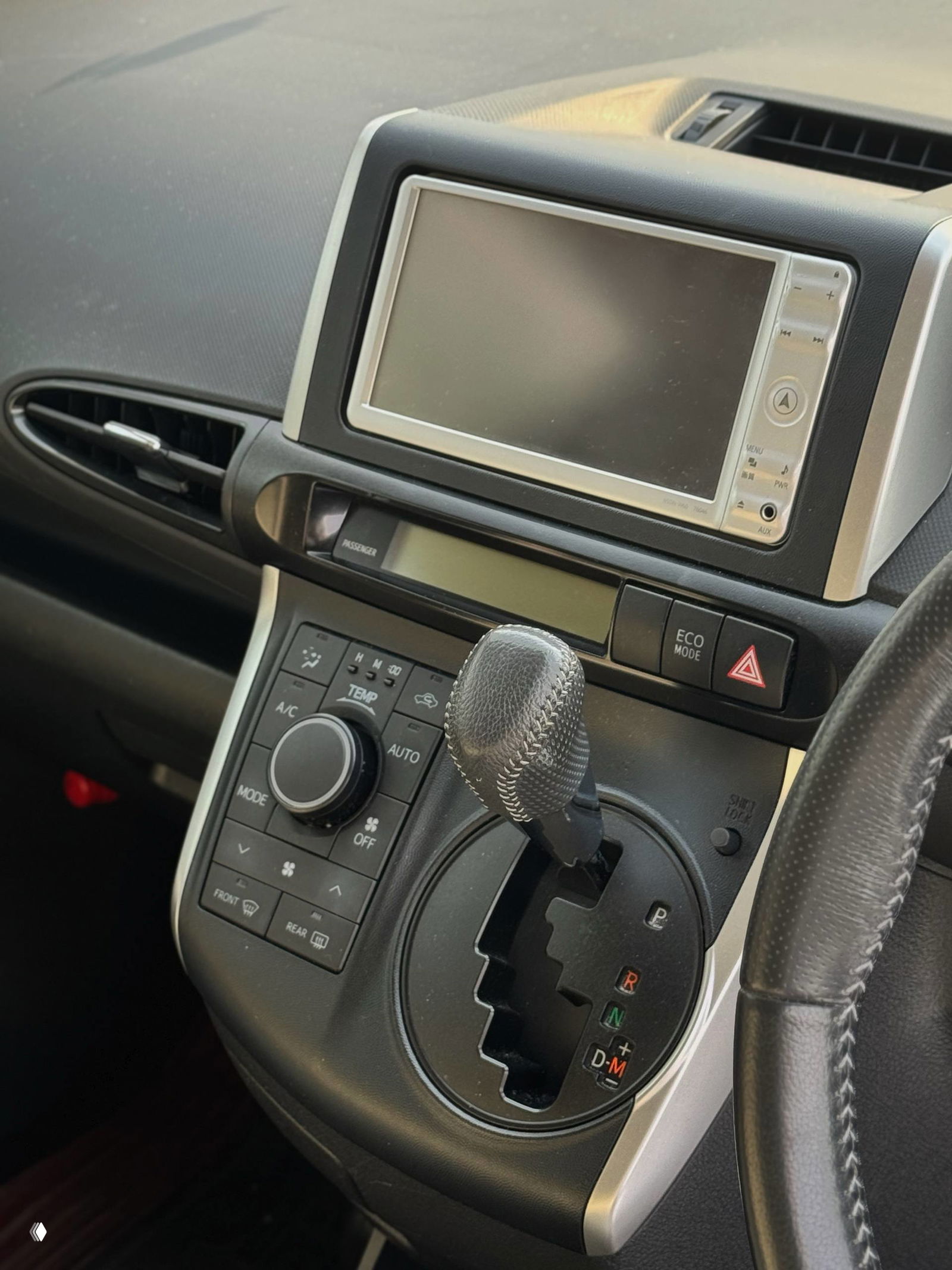Салон: центральная консоль с селектором коробки передач и мультимедийным экраном — крупный план на рычаг и блок климат-контроля.